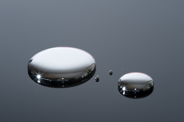 Droplets of mercury on a reflective surface.