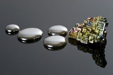 Droplets of mercury and bismuth on a reflective surface. - obrazy, fototapety, plakaty
