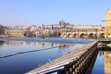 Obraz premium First Snow in Prague, gothic Castle with the Charles Bridge