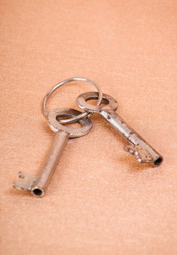 Metal keys on golden textile background