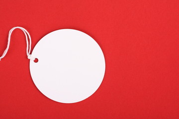 Blank White circle shaped gift tag on red textured paper
