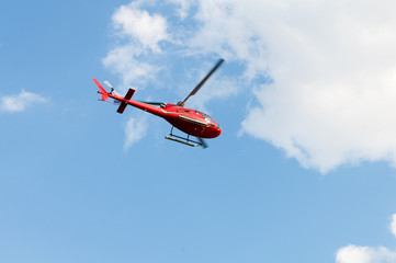Fototapeta na wymiar Red helicopter on the bright summer day