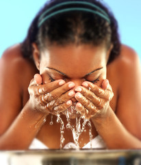 Mujer afroamericana lavando su rostro.