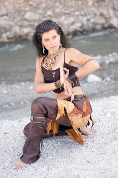 Beautiful woman in tribal style holding yoga mudra hands.