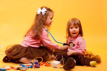 Naklejka premium Two cute little sisters playing with toys