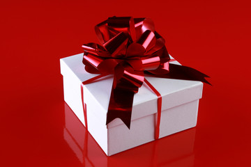 Christmas gift box with a dark-red ribbon bow
