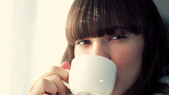 Young smiling woman haivng a cup of tea