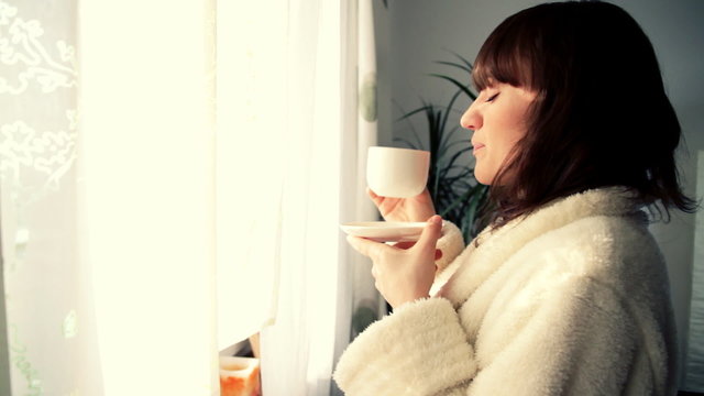 Young smiling woman haivng a cup of tea