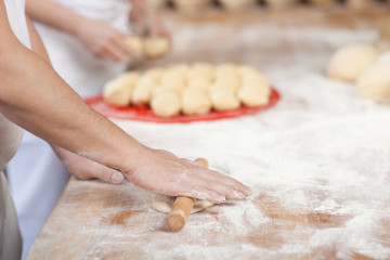 bäcker rollt teig aus