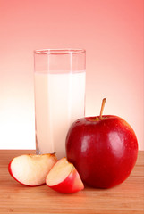 Apple and milk on red background