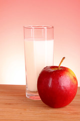 Apple and milk on red background