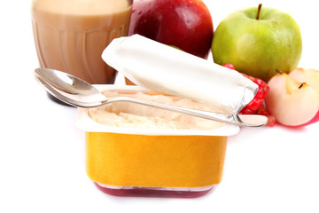 Yoghurt, muesli, milk and fruits isolated on white