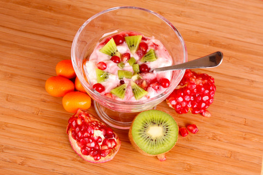 some coctail with fruits in glass with spoon on red background