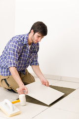 Obraz na płótnie Canvas Home improvement - handyman laying tile