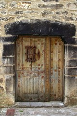 Medieval wooden door in stone wall Pyrenees