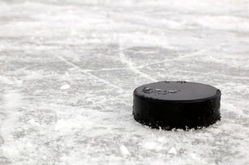 black hockey puck on ice rink - 28287084