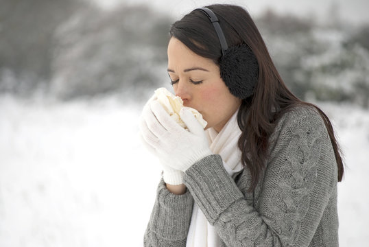 Woman sneezing in the snow