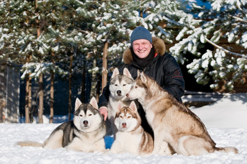 Man with group of siberian husky at winter