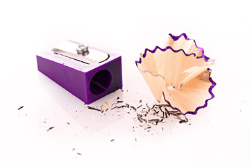 Pencil sharpener and wood shavings isolated on white