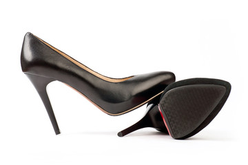 Two black female shoes, suede and leather ones, on white