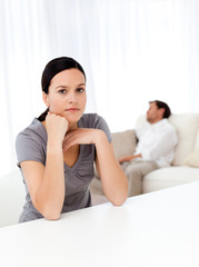 Obraz na płótnie Canvas Worried woman in the living room while her boyfriend sleeping
