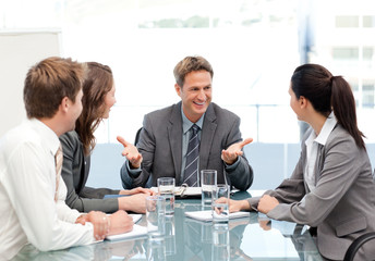 Cheeful manager talking to his team at a meeting