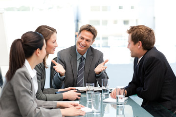 Delighted managertalking to his team at a table