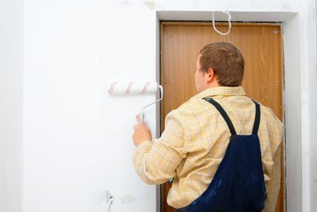 Fototapeta premium worker painting wall with roller