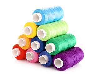 Pyramid of many-coloured bobbins of thread isolated on white