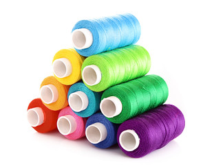Pyramid of many-coloured bobbins of thread isolated on white
