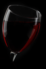 half of red wine glass isolated on black background