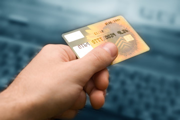credit card in hand for purchases are in the internet