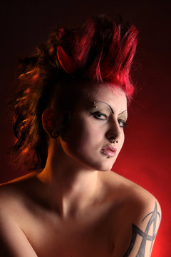 Eine nackt Frau als Punkerin mit Irokesenfrisur in Rot