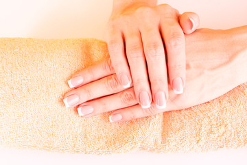 Naklejka premium Beautiful woman hands with french manicure on yellow background