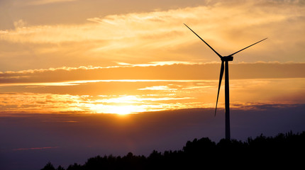 Fototapeta na wymiar Wind turbine farm over sunset