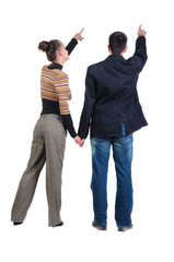 Young couple pointing at wall. Rear view.