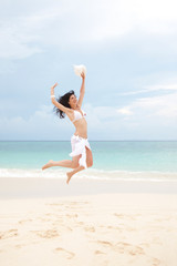Fototapeta na wymiar happy young woman jumping in the beach