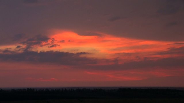 Dramatic orange sunset with violet clouds, timelapse