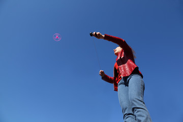 woman in red jacket and blue jeans playing with pinwheel toy