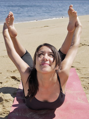 Bikram yoga dhanurasana pose at beach