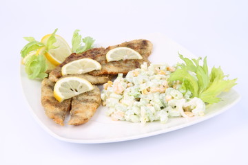Fried fish with side salad decorated with lemon