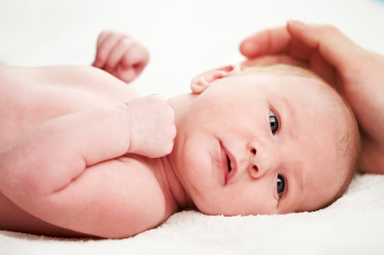 newborn baby under adult hand protection