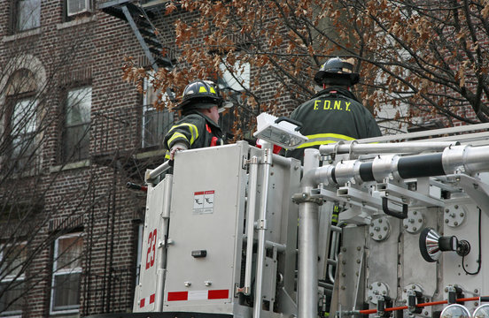 Firemen in bucket of ladder truck