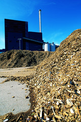 bio power plant with storage of wooden fuel against blue sky