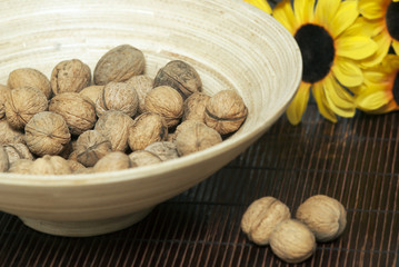 wooden bowl with walnuts on mat