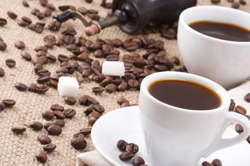 Obraz na płótnie Canvas cups of coffee, beans and grinder on sack