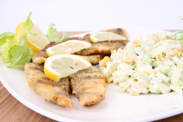 Fried fish with side salad decorated with lemon