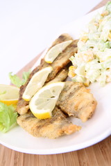 Fried fish with side salad decorated with lemon
