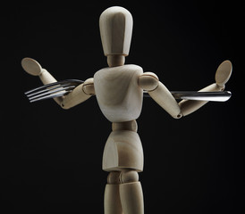 Wooden dool figure with cutlery.