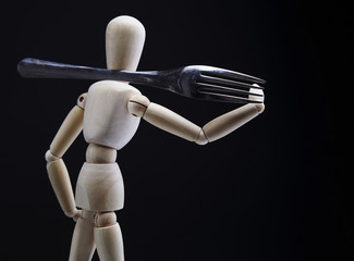 Wooden dool figure with cutlery.